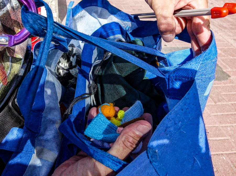 Robert Lacombe carries a shopping bag filled with needles, yarn and finger puppets he has made for children he meets. (Ash Abraham/CBC) 