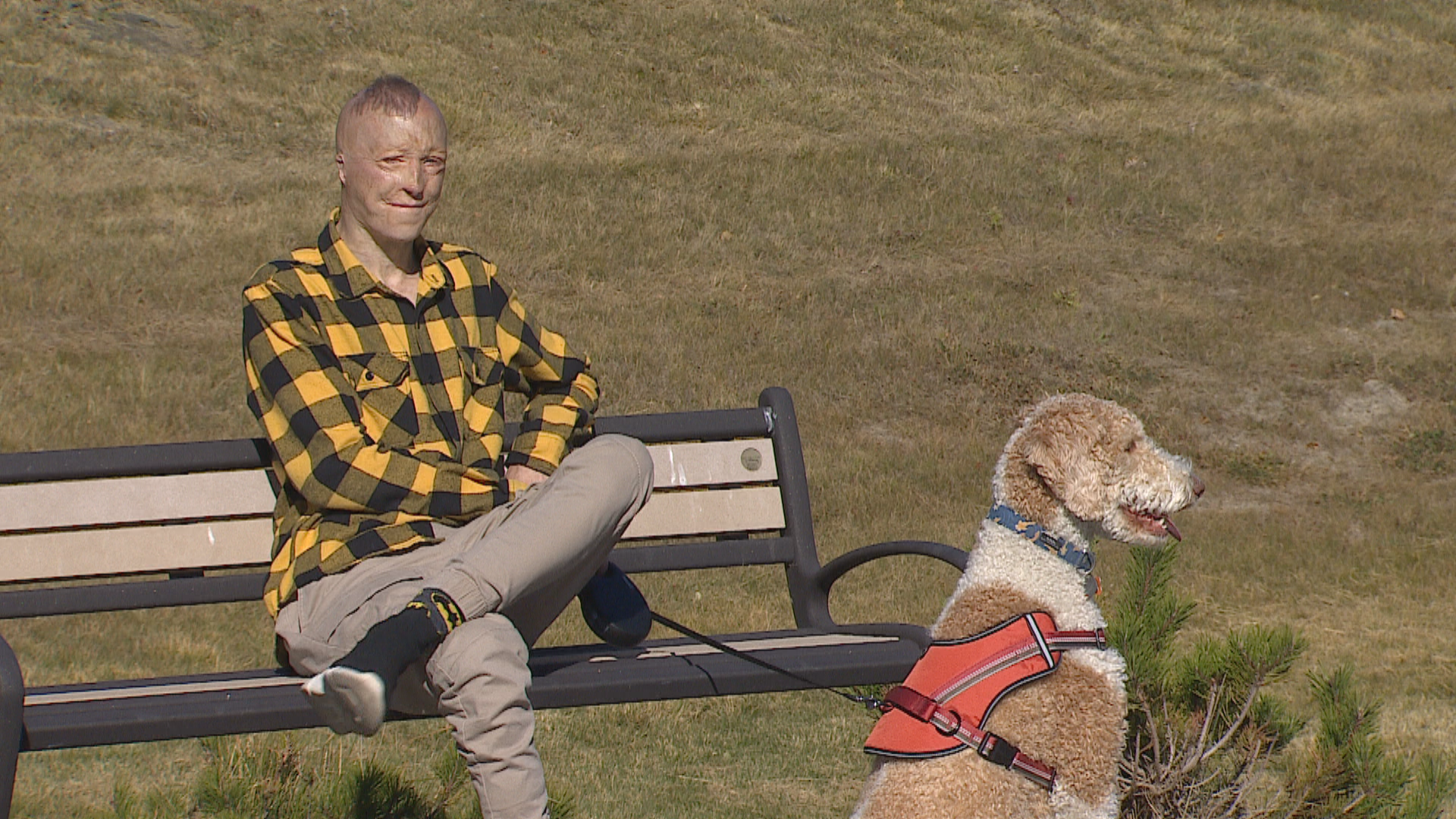 Kyle Hynes sits on a bench, taking a break from walking his dog Simba, on a trail near his home. (Justin Pennell/CBC)