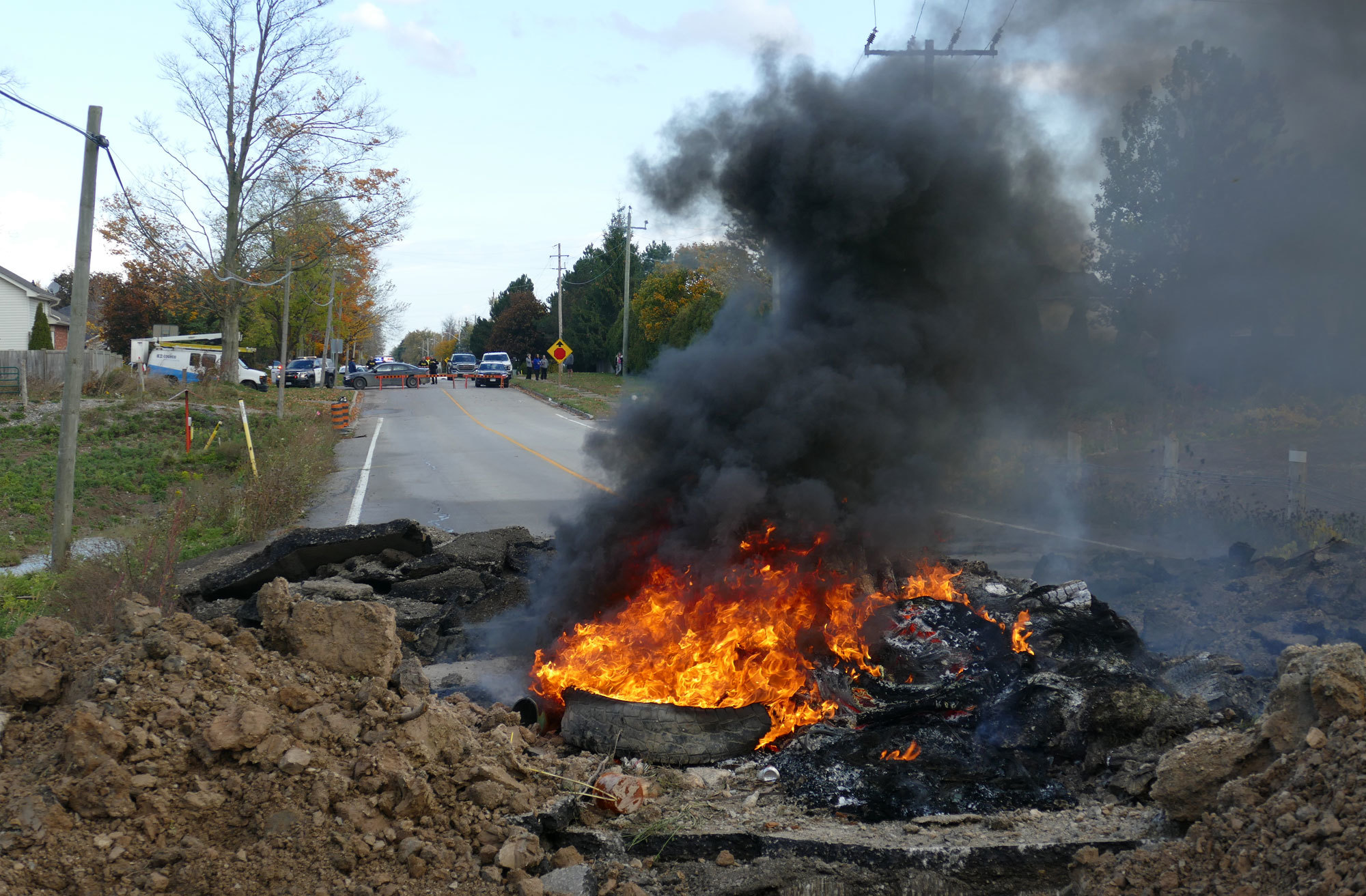 A tire fire set next to a trench dug in the road near the entrance to the McKenzie Meadows development, renamed 1492 Land Back Lane. (Jorge Barrera/CBC)