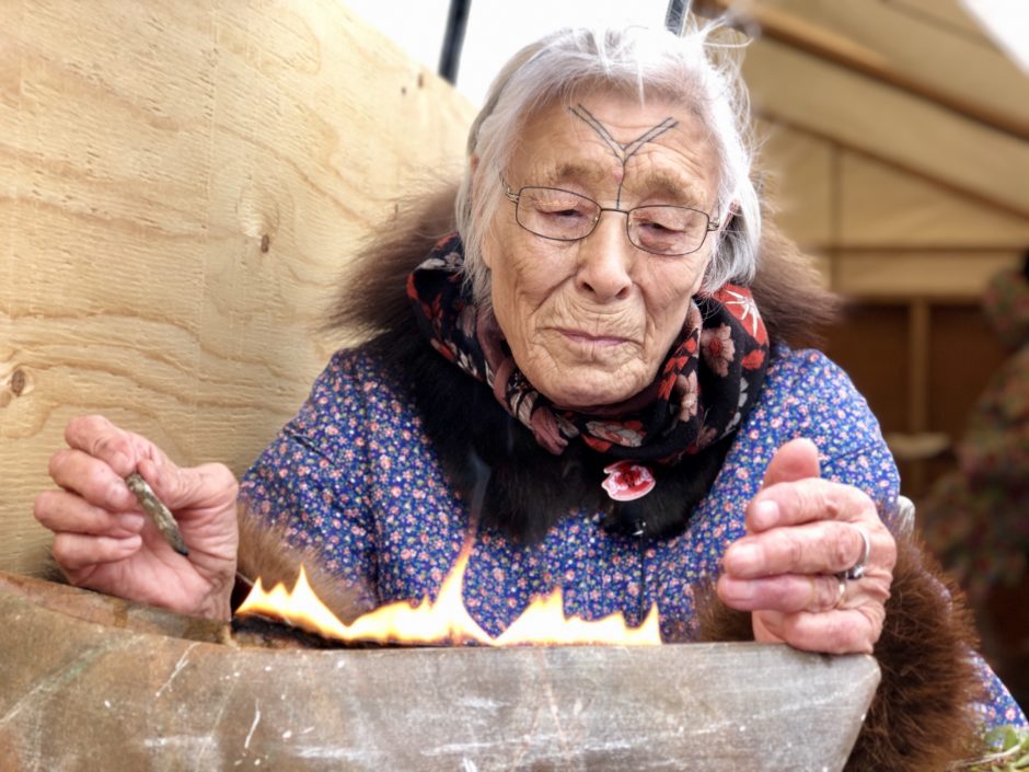 Bessie Pihoak Omilgoetok lights a qulliq — a traditional Inuit stone lamp. It's a skill that was passed on to her from her grandmother, and now she's hoping to pass it on to the next generation of Inuit. (Kate Kyle/CBC)