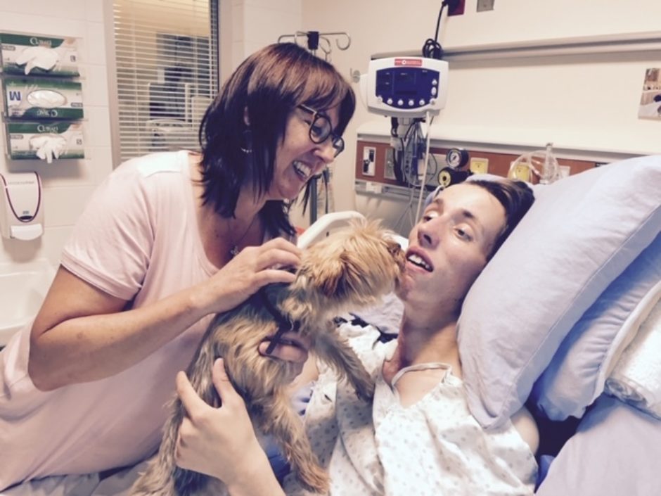 Brandon Chase enjoys a hospital visit with mother Pamela Davis and Zoe, the family dog.