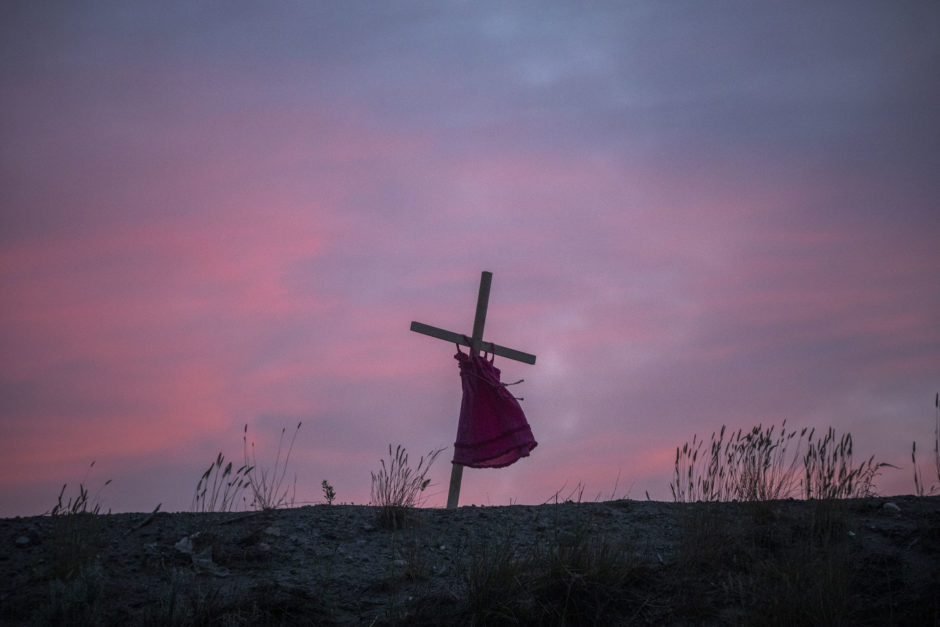 The silhouette of a red dress is seen on the hillside before sunset in Kamloops, B.C.