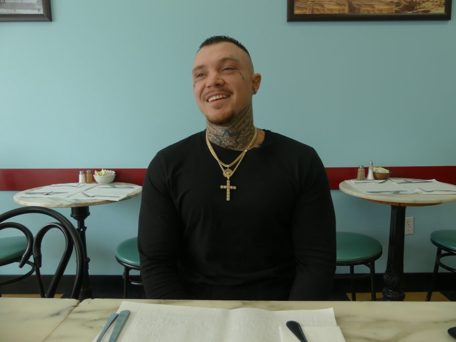 Philip Pynn sits at a café near his halfway house in Dartmouth, N.S. (Ariana Kelland/CBC)