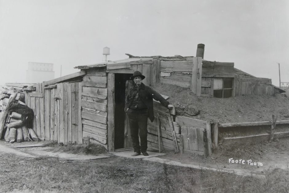 An old man stands outside a shack made of dirt and wood in the slums of Winnipeg between 1906 and 1910. (Foote collection/Archives of Manitoba)