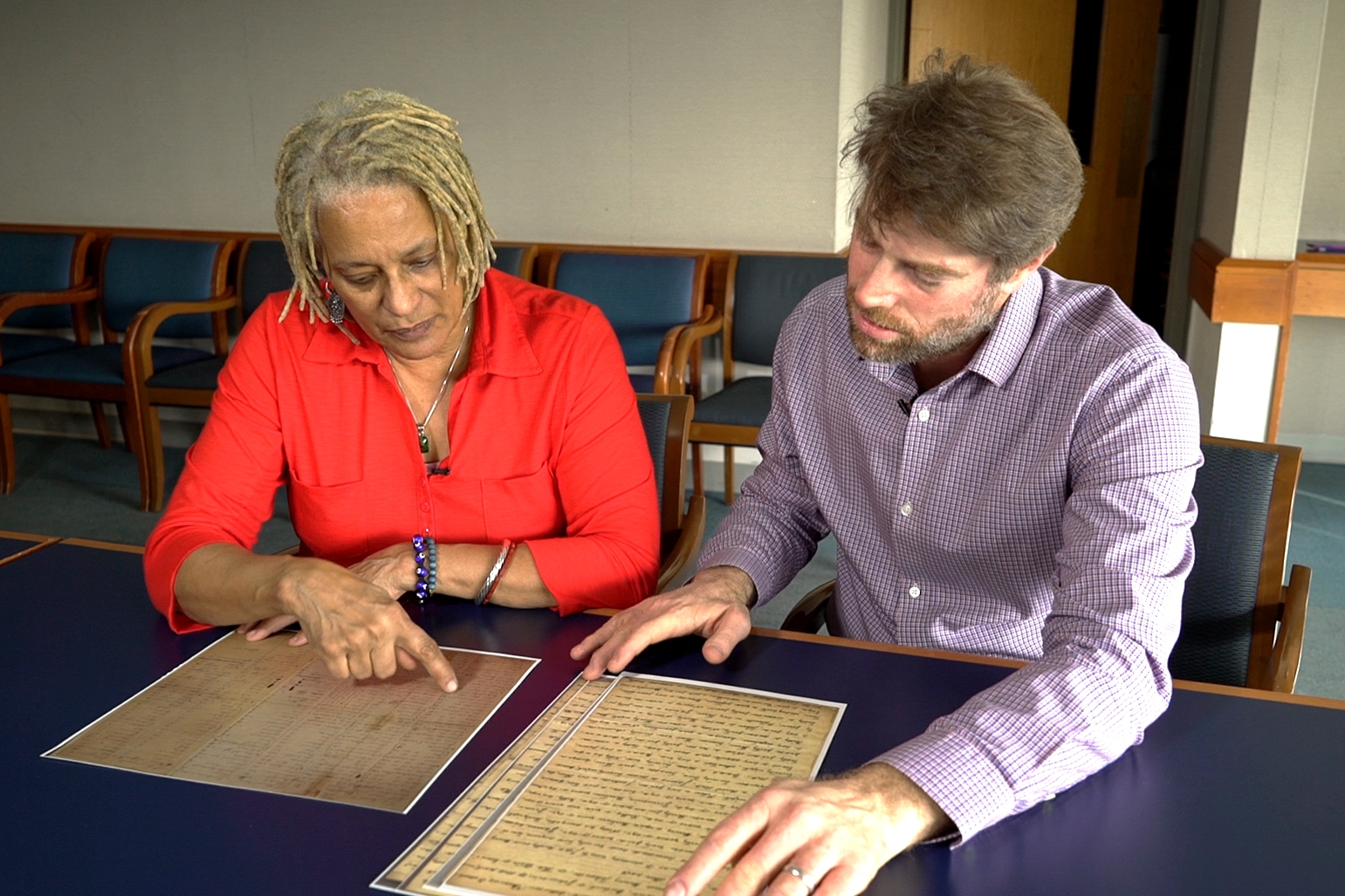 Meli Short-Colomb pores over documents related to the sale with professor Adam Rothman, who now runs the Slavery Archive at Georgetown. (Jason Burles/CBC) 