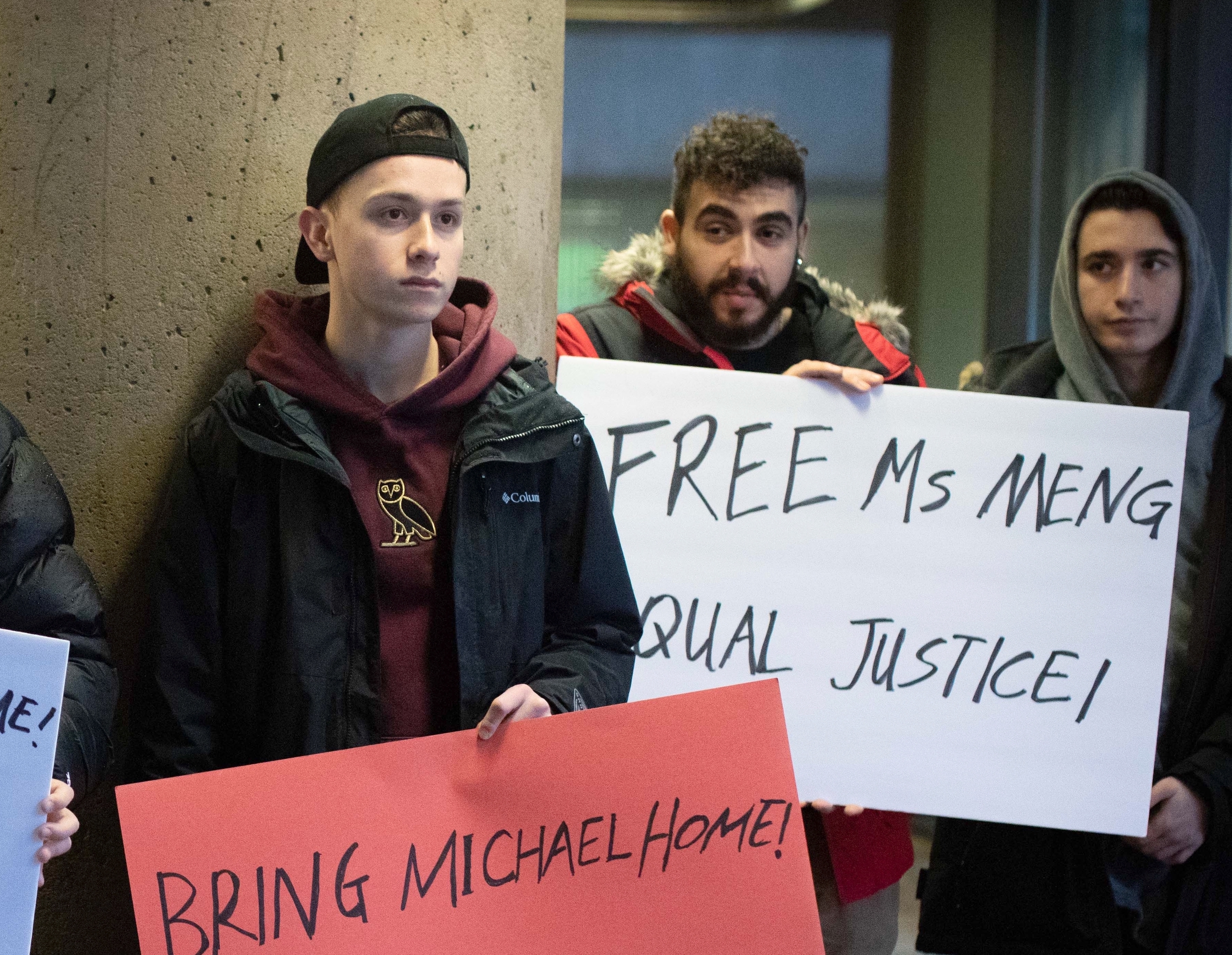 According to people paid to protest at Meng's January hearing in Vancouver, a woman named Joey provided them with the signs. (Maggie MacPherson/CBC)