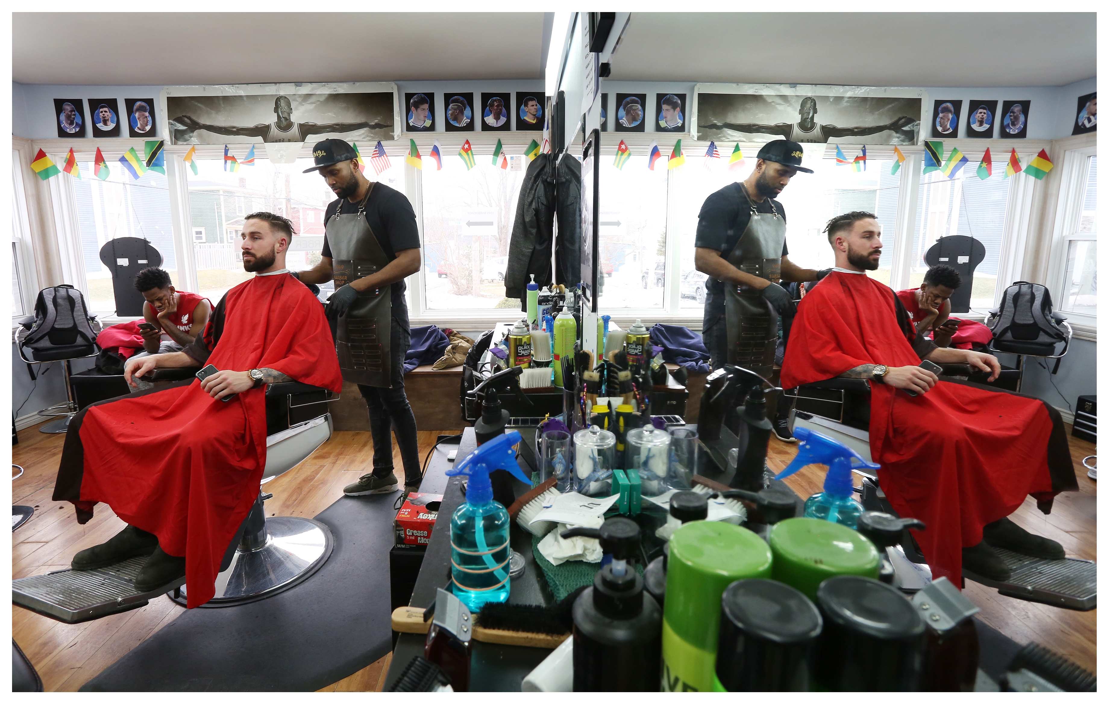 Liam Condon gets a haircut from co-owner Gustav Valoyes, as Sea-Hawk Daniel Gordon waits for his turn. (Paul Daly)