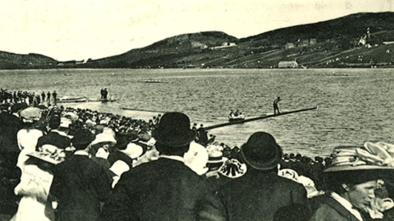 A crowd watches as someone attempts the greasy pole contest at the Regatta in the 1900s. (The Rooms)