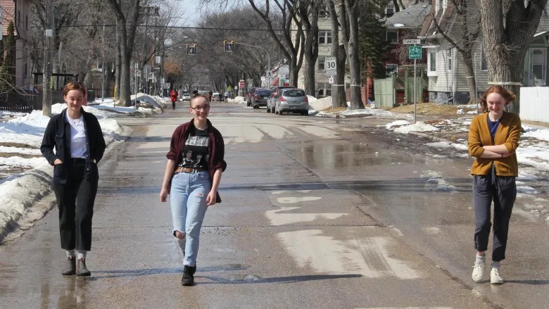 Together but apart. Mackenna and Javelin Robertson, left, keep their distance from their sister Sequoia, who was living apart from them at the time, as they walk down a Wolseley neighbourhood street closed to cars in April. (Ian Froese/CBC)