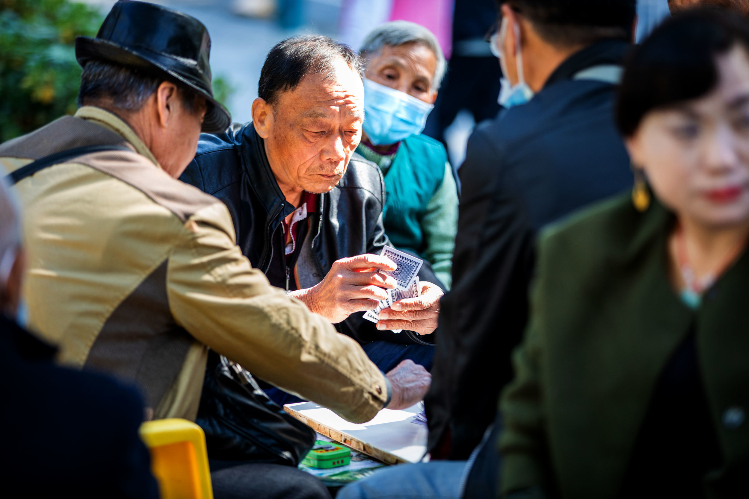 Daily life has returned to Wuhan’s parks and squares, where COVID-19 seems forgotten and even masks rarely interfere with a game of cards. (Saša Petricic/CBC)