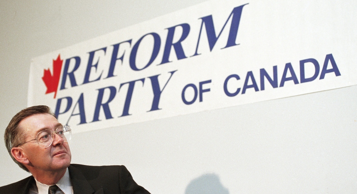 Preston Manning pauses in front of a Reform Party of Canada sign during a news conference in Ottawa on Nov. 27, 1991. (Ron Poling/The Canadian Press)