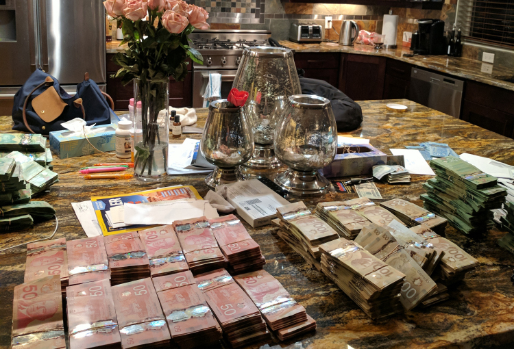 This image, of cash stacked on Cotten’s kitchen counter at his home in Kelowna, B.C., was part of the evidence collected by the Ontario Securities Commission in its investigation of QuadrigaCX. (Ontario Securities Commission)