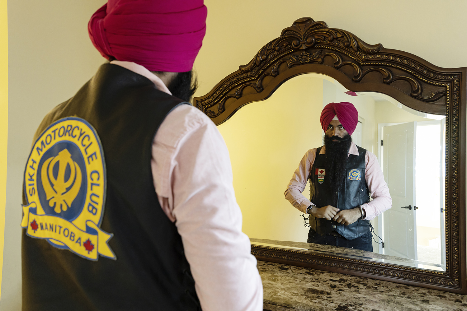 Rajwinder Singh Sandhu at his home, in the northeast area of Winnipeg, suiting up in his motorcycle gear just before leaving on a ride. (Prabhjot Singh Lotey/CBC)