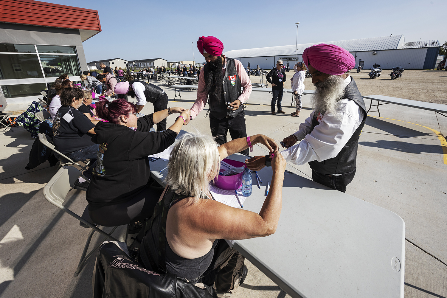 Singh Sandhu and Manjit Singh register for the 20th annual breast cancer pledge ride at TC Energy Centre in Île-des-Chênes, Man. (Prabhjot Singh Lotey/CBC)