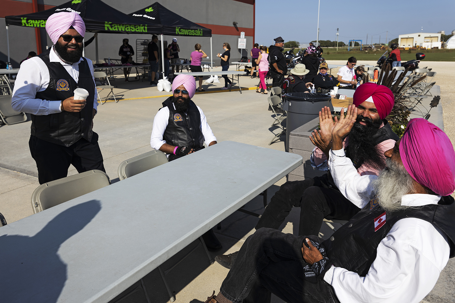 Bikers enjoying a conversation at the community centre during the pledge ride in support of breast cancer research. Riding for years together has created a strong bond between club members, and everyone looks forward to spending time together. (Prabhjot Singh Lotey/CBC)