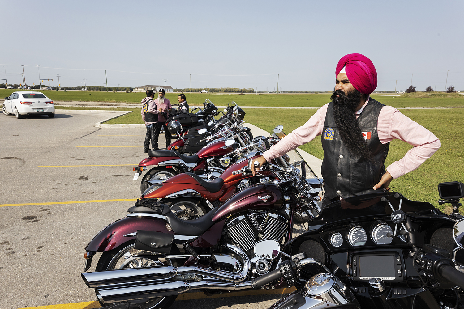 Singh Sandhu looks on as bikers make a stop in Selkirk, Man.