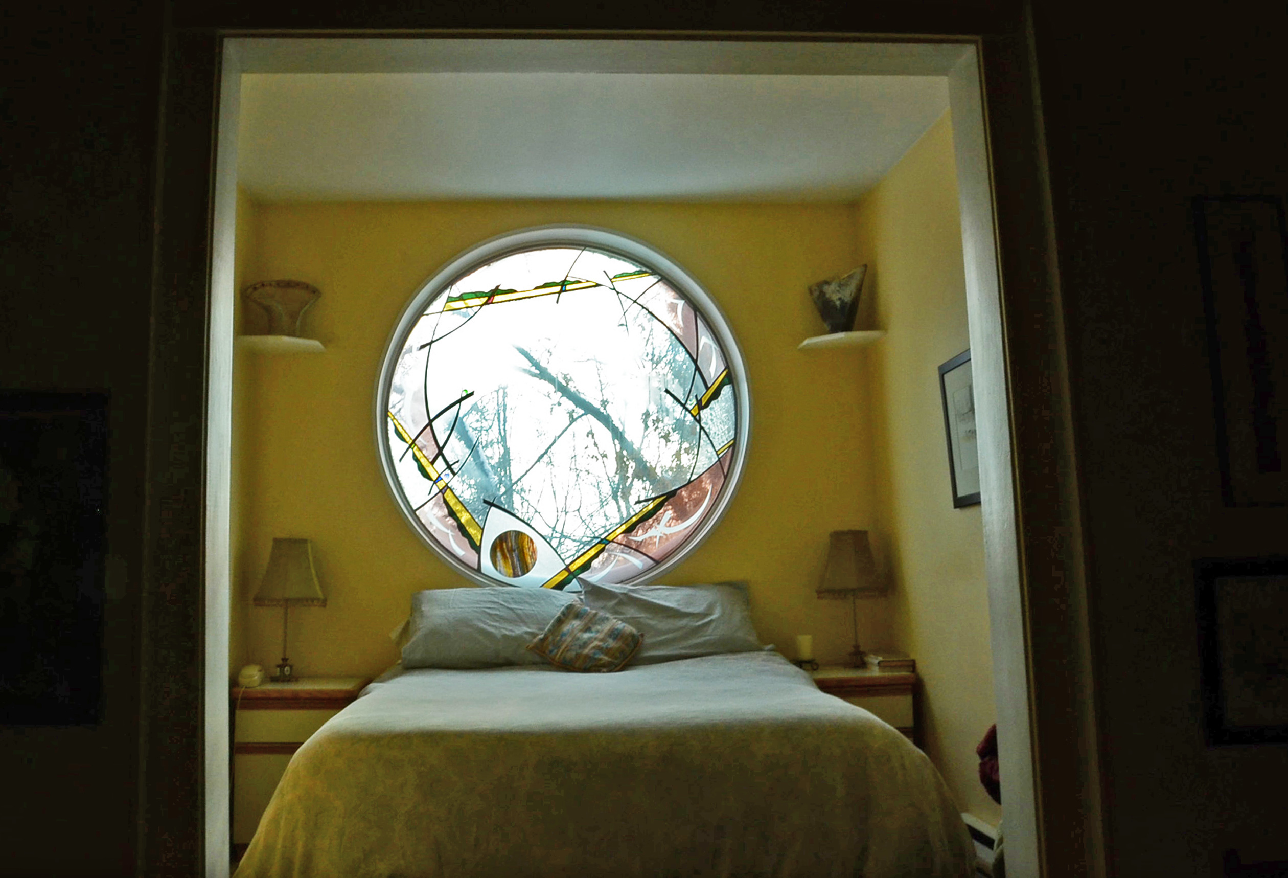 The master bedroom of Holden and Bolen's home is outfitted with a custom stained glass window. (Bridget Yard/CBC)