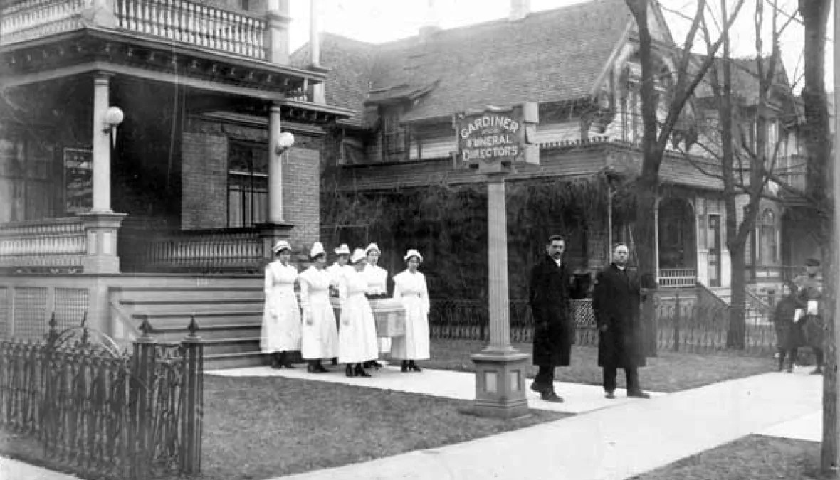 Nurses hold a casket outside Winnipeg's Gardiner Funeral Home during the flu epidemic of 1918-1919. (L.B. Foote Collection/Archives of Manitoba)