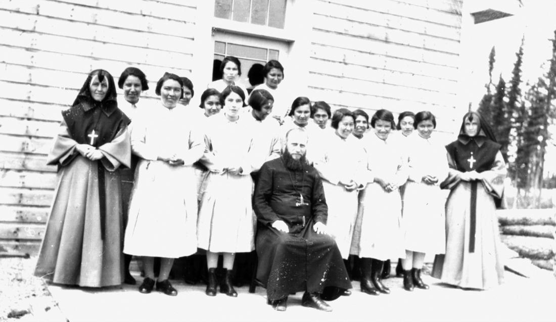 Grey nuns and a priest with students at St. Anne's in the 1940s. (Algoma University/Edmund Metatawabin Collection)