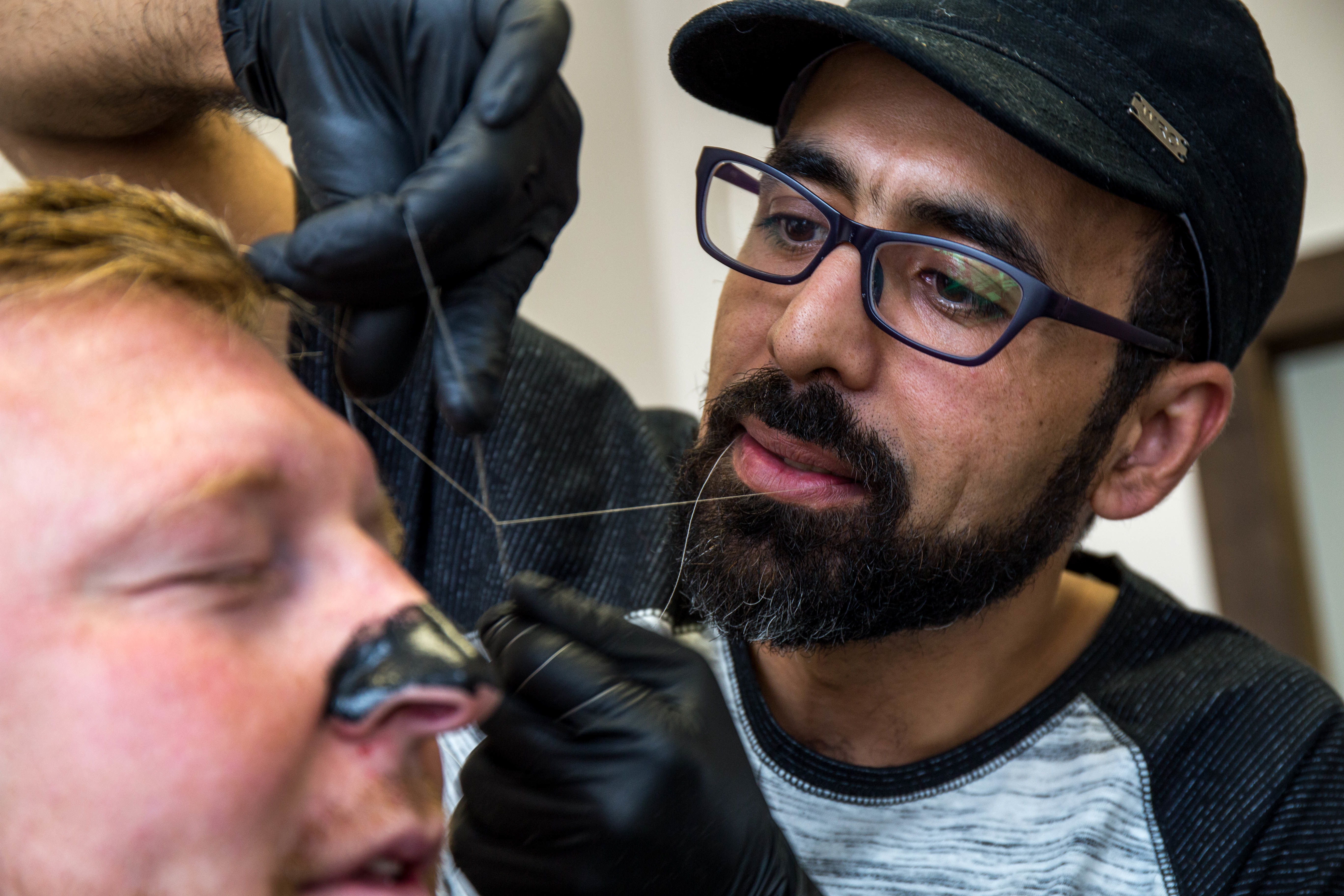 Mohamad Almaidani uses' old school' techniques, including thread and razors, to give his customers a polished look. (Lindsay Bird/CBC)