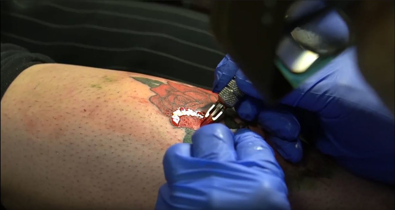 Tony D’Annessa tattoos a rose on a customer. He says even though tattooing gets harder as he gets older, it’s not a career someone retires from. (Tobias Cassidy)