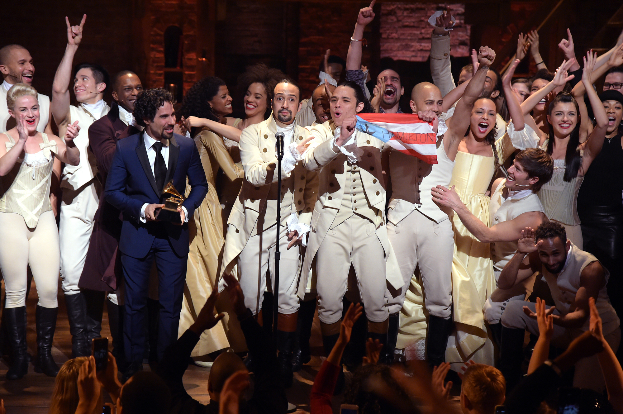 Cast and crew of Hamilton, including composer Lin-Manuel Miranda, at the microphone, celebrate on stage during a performance at the Grammy Awards on Feb. 15, 2016, in New York. (Theo Wargo/Getty Images)