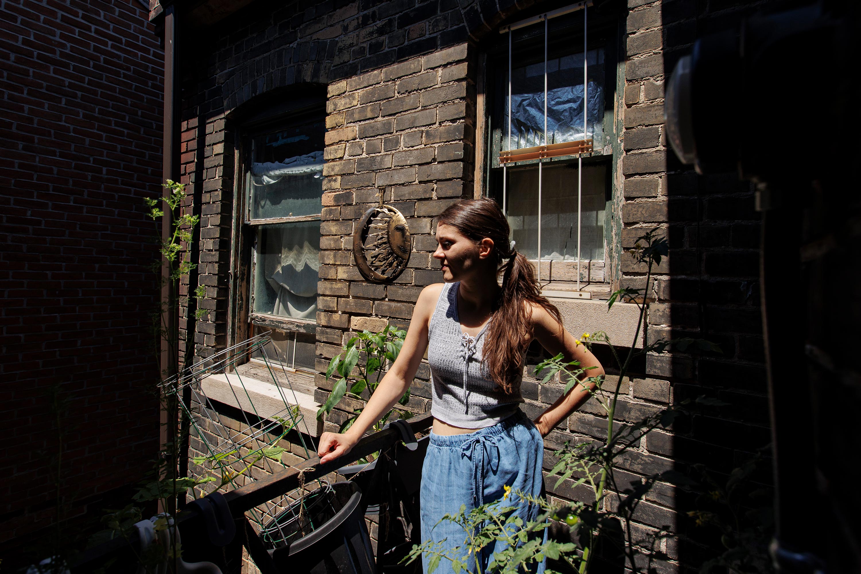 Leigh tends to potted vegetables on her fire escape on June 13, 2022.